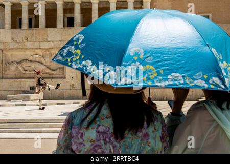 230713 -- ATENE, 13 luglio 2023 -- persone riparano dal sole sotto un ombrello ad Atene, in Grecia, 12 luglio 2023. Foto di /Xinhua GREECE-ATHENS-HEAT PanagiotisxMoschandreou PUBLICATIONxNOTxINxCHN Foto Stock