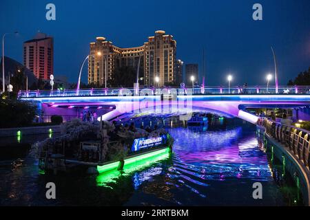 230713 -- PECHINO, 13 luglio 2023 -- i turisti fanno un tour serale in barca lungo il fiume Liangma a Pechino, capitale della Cina, il 25 giugno 2023. La Senna, il secondo fiume più grande della Francia, si snoda attraverso il cuore di Parigi. Scorrendo da ovest a est, divide la città nelle iconiche sponde sinistra e destra . La riva sinistra è caratterizzata da un'atmosfera artistica, adornata da caffè, teatri e librerie, che creano un paradiso per il circolo letterario e un paradiso culturale. D'altra parte, la riva destra ospita prestigiosi monumenti storici come il Louvre, l'ex palazzo reale e El Foto Stock
