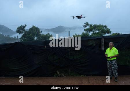 230723 -- JIANGCHENG, 23 luglio 2023 -- Diao fax, membro di una squadra di monitoraggio degli elefanti, lancia un drone per tracciare il movimento degli elefanti selvatici asiatici nella contea di Jiangcheng, nella provincia dello Yunnan della Cina sud-occidentale, il 20 luglio 2023 grazie a sforzi senza compromessi per la protezione ambientale e della fauna selvatica, la popolazione di elefanti asiatici selvatici nello Yunnan è cresciuta negli ultimi anni. Sentendosi molto più al sicuro di prima, alcuni di questi elefanti sono diventati sempre più dilaganti e un audace tour di gruppo di una famiglia di elefanti nella provincia ha persino fatto una grande scena nel cyberspazio globale nel 2021. Ji Foto Stock