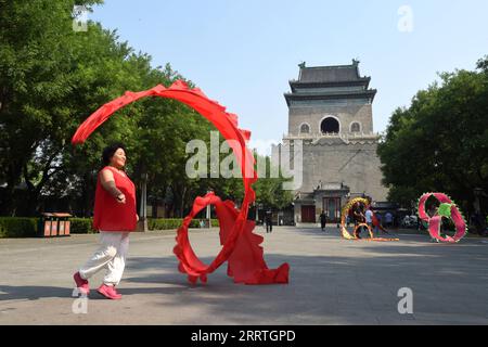 230725 -- PECHINO, 25 luglio 2023 -- gente esercitazione davanti al Campanile di Pechino, capitale della Cina, 18 luglio 2023. Creato per la prima volta nella dinastia Yuan 1271-1368, l'asse centrale di Pechino, o Zhongzhouxian, si estende per 7,8 chilometri tra la porta Yongding nel sud della città e la Torre del tamburo e la Torre Campanaria nel nord. La maggior parte dei principali edifici della città vecchia di Pechino si trovano lungo questo asse. Porte, palazzi, templi, piazze e giardini della città vecchia sono tutti collegati all'asse. Mentre assistevano alle attività popolari lungo la linea, dai vecchi tempi a quelli nuovi, loro stessi sono un Foto Stock