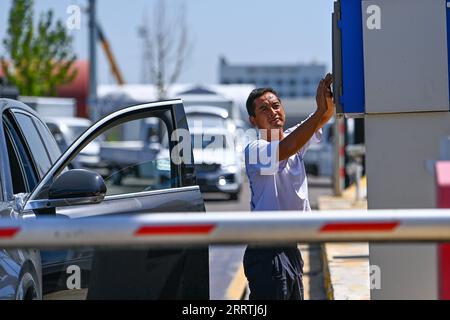 230727 -- HORGOS, 27 luglio 2023 -- Un autista strizza una carta per entrare nel checkpoint dei veicoli della dogana di Horgos nella regione Autonoma dello Xinjiang Uygur della Cina nord-occidentale, 26 luglio 2023. Sempre più automobili prodotte a livello nazionale sono state esportate attraverso il porto di Horgos, uno dei porti cinesi più vicini all'Asia centrale e all'Europa tramite trasporto terrestre, verso paesi lungo la cintura e la strada, tra cui Kazakistan, Uzbekistan e Russia. CHINA-XINJIANG-HORGOS-VEHICLES-EXPORT CN DINGXLEI PUBLICATIONXNOTXINXCHN Foto Stock