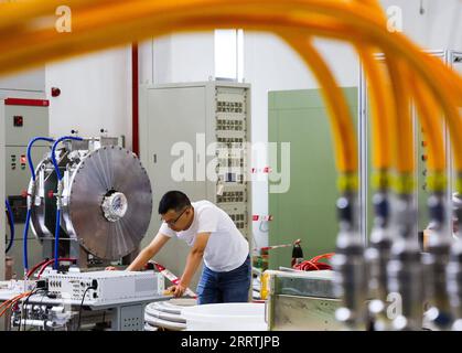 230727 -- GUANGZHOU, 27 luglio 2023 -- Un ricercatore gestisce apparecchiature presso il laboratorio di tecnologia a radiofrequenza dell'acceleratore della sorgente CSNS di neutroni di spallazione della Cina a Dongguan, nella provincia del Guangdong della Cina meridionale, 18 luglio 2023. Nella città di Dongguan si trova un progetto sci-tech di livello mondiale -- China Spallation Neutron Source CSNS. Da quando è stata avviata, nell'agosto 2018, sono stati affrontati oltre 1.000 compiti di ricerca. Soprannominato un super microscopio, una sorgente di neutroni di spallazione può produrre e accelerare i protoni prima di sfonderli nel bersaglio per produrre neutroni, e i fasci di neutroni saranno diretti verso Foto Stock