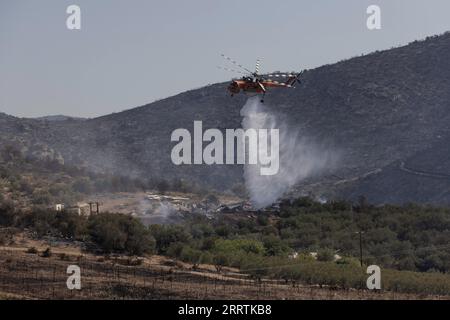 230729 -- ATENE, 29 luglio 2023 -- Un elicottero da vigile del fuoco cerca di spegnere il fuoco nella città greca centrale di Nea Anchialos, il 28 luglio 2023. I vigili del fuoco stavano ancora combattendo fiamme riaccese in alcune parti della Grecia venerdì, mentre gli incendi che infuriavano in tutto il paese per due settimane si sono lentamente abbattuti. La situazione è migliorata anche nella zona di Greater Volos, dove giovedì un incendio ha innescato una serie di esplosioni in un deposito di munizioni della base dell'aeronautica militare di Nea Anchialos, ha riferito l'agenzia di stampa nazionale greca AMNA. Foto di /Xinhua GREECE-WILDFIRE-AFTERMATH LefterisxPartsalis PUBLICATIONxN Foto Stock