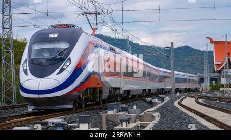 230817 -- KUNMING, 17 agosto 2023 -- il treno passeggeri Lane Xang della China-Laos Railway passa davanti a un centro di manutenzione a Luang Prabang, Laos, 30 marzo 2023. Foto di /Xinhua Xinhua titoli: Dieci anni dopo, il commercio Cina-Asia meridionale raddoppia sui legami più stretti ZhouxXing PUBLICATIONxNOTxINxCHN Foto Stock