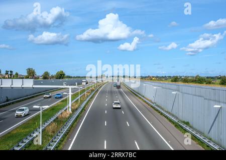 Autostrada A4 moderna e profonda attraverso una riserva naturale vicino a Rotterdam, direzione del traffico l'Aia, Paesi Bassi Foto Stock