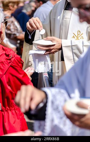 Attenzione selettiva, sacerdoti cattolici che distribuiscono il wafer della comunione Foto Stock