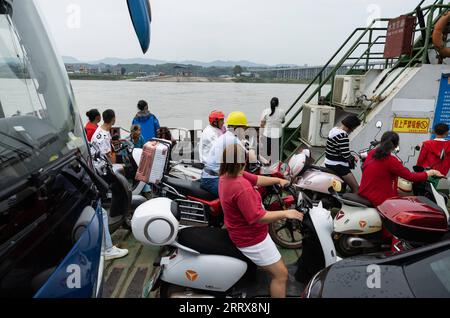 230828 -- YIBIN, agosto 28, 2023 -- veicoli e passeggeri prendono il traghetto attraverso il fiume che collega la città di Nixi e la città di Juexi nel distretto di Xuzhou di Yibin, provincia del Sichuan della Cina sud-occidentale, agosto 28, 2023. Il servizio di traghetto attraverso il fiume che collega la città di Nixi e la città di Juexi nel distretto di Xuzhou di Yibin è iniziato nel maggio 1992. Questo servizio di traghetto e' stato uno dei piu' importanti metodi di trasporto per le persone locali che vivono nelle vicinanze su entrambi i lati del fiume Minjiang. Dato che il grande ponte di Nixi Minjiang ha aperto al traffico qui il lunedì, anche il servizio di traghetto vecchio di 31 anni è terminato lo stesso giorno. La Foto Stock