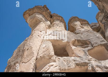 Abitazioni scolpite in pietra, in formazioni rocciose vulcaniche erose dall'acqua, camini delle fate, nel museo all'aperto di Goreme, in Cappadocia, turchia Foto Stock