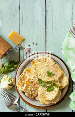 Cotolette vegetariane fritte o pancake. Frittelle di cavolfiore con formaggio su un tavolo da cucina rustico. Vista dall'alto. Copia spazio. Foto Stock