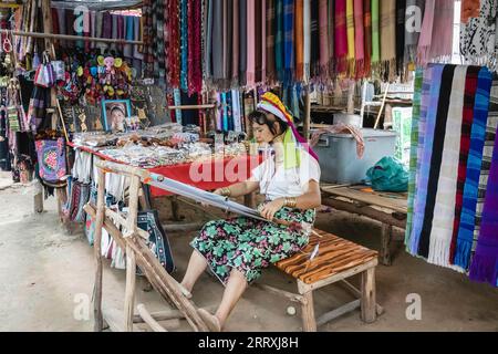 Una donna Karen è vista tessere al Long Neck Karen Village. Il gruppo tribale Karen, a causa del conflitto con il regime militare in Myanmar, tra la fine degli anni '1980 e l'inizio degli anni '1990, è fuggito nella zona di confine tailandese nei campi profughi e anche dopo anni di vita in Thailandia, gli viene ancora negato cittadinanza tailandese hanno anche accesso limitato all'elettricità, alle strade, assistenza sanitaria, e scuole, così alcuni dei campi sono diventati un sito turistico, autosufficiente sulle entrate turistiche e non hanno bisogno di assistenza finanziaria. Foto Stock