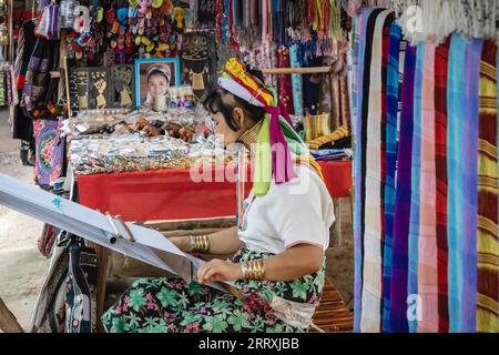 Una donna Karen è vista tessere al Long Neck Karen Village. Il gruppo tribale Karen, a causa del conflitto con il regime militare in Myanmar, tra la fine degli anni '1980 e l'inizio degli anni '1990, fuggì nella zona di confine tailandese nei campi profughi e anche dopo anni di vita in Thailandia, continuano a essere rifiutati la cittadinanza thailandese ha anche un accesso limitato all'elettricità, alle strade, all'assistenza sanitaria e alle scuole, quindi alcuni dei campi sono diventati un sito turistico, autosufficiente sulle entrate turistiche e non hanno bisogno di assistenza finanziaria. (Foto di Nathalie Jamois/SOPA Images/Sipa USA) Foto Stock