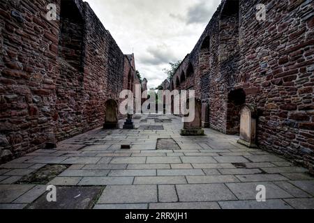 Cattura l'essenza della storia e della tranquillità con questa suggestiva fotografia del cimitero del priorato e delle rovine della chiesa. Perfettamente inquadrata, l'immagine si evolve Foto Stock