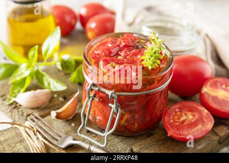 Pomodori secchi in vaso con spezie ed erbe aromatiche. Cibo fermentato sano fatto in casa. Economia domestica, conservazione del raccolto autunnale. Foto Stock