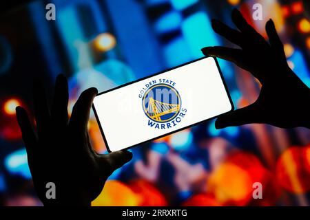 In questa immagine, il logo Golden State Warriors viene visualizzato sullo schermo di uno smartphone. È una squadra di pallacanestro professionistica americana. I Warriors competono nella National Basketball Association (NBA). Foto Stock