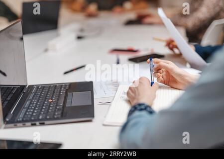 Foto ravvicinata di un dipendente che gioca con la penna durante una riunione al lavoro Foto Stock