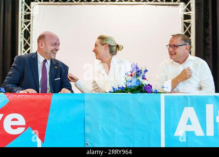 09 settembre 2023, Assia, Gelnhausen: Robert Lambrou (l-r, AfD), presidente dello stato AfD/candidato leader per le elezioni statali, Alice Weidel (AfD), presidente del partito federale, e Tino Chrupalla (AfD), presidente del partito federale, siedono insieme sul podio. L'Hessian AfD tiene la sua campagna d'avvio per le elezioni statali in Assia nella sala dello sport e della cultura di Meerholz. Diverse associazioni e istituzioni manifestano ai margini dell'evento AfD con lo slogan "siamo di più! - Festival della democrazia e della coesione sociale". Le elezioni in Assia si svolgeranno l'8 ottobre 2023. Foto: Foto Stock