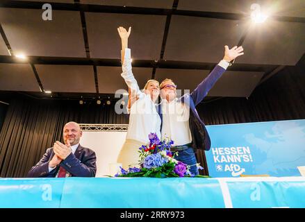 09 settembre 2023, Assia, Gelnhausen: Robert Lambrou (l-r, AfD), presidente dello stato AfD/candidato leader per le elezioni statali, Alice Weidel (AfD), presidente del partito federale, e Tino Chrupalla (AfD), presidente del partito federale, si uniscono sul podio. L'Hessian AfD tiene la sua campagna d'avvio per le elezioni statali in Assia nella sala dello sport e della cultura di Meerholz. Diverse associazioni e istituzioni manifestano ai margini dell'evento AfD con lo slogan "siamo di più! - Festival della democrazia e della coesione sociale". Le elezioni in Assia si svolgeranno l'8 ottobre 2023. Phot Foto Stock