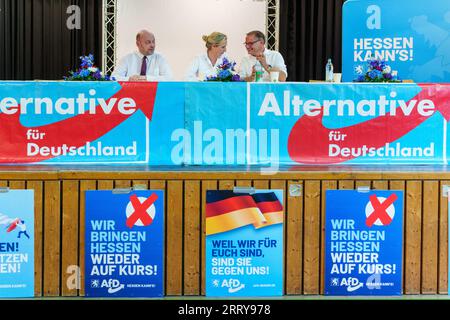 09 settembre 2023, Assia, Gelnhausen: Robert Lambrou (l-r, AfD), presidente dello stato AfD/candidato leader per le elezioni statali, Alice Weidel (AfD), presidente del partito federale, e Tino Chrupalla (AfD), presidente del partito federale, siedono insieme sul podio. L'Hessian AfD tiene la sua campagna d'avvio per le elezioni statali in Assia nella sala dello sport e della cultura di Meerholz. Diverse associazioni e istituzioni manifestano ai margini dell'evento AfD con lo slogan "siamo di più! - Festival della democrazia e della coesione sociale". Le elezioni in Assia si svolgeranno l'8 ottobre 2023. Foto: Foto Stock