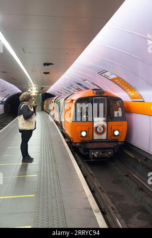 Treno della metropolitana SPT che arriva alla stazione della metropolitana di Glasgow Kinning Park sulla metropolitana di Glasgow con passeggeri in attesa sul binario Foto Stock