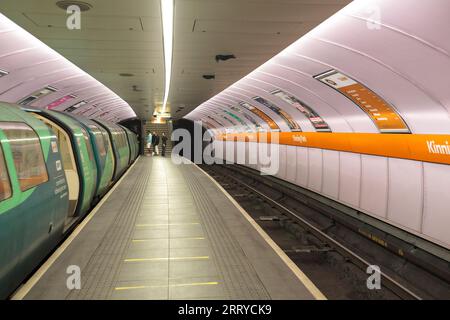 Stazione di Kinning Park sulla metropolitana SPT Glasgow che mostra la stretta piattaforma dell'isola e un treno nella stazione Foto Stock