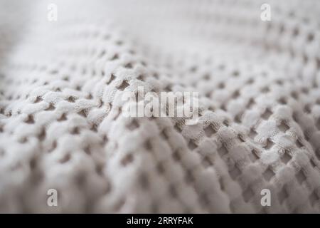 Primo piano della consistenza di un lancio tessile beige realizzato con tessuti naturali Foto Stock