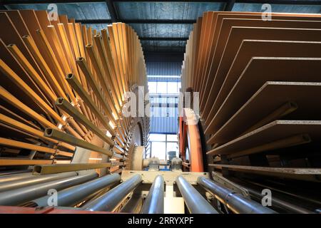 I lavoratori controllano i macchinari per produrre lastre sulla linea di produzione Foto Stock