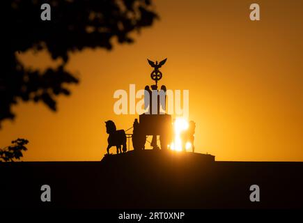 Berlino, Germania. 10 settembre 2023. Il sole sorge dietro la porta di Brandeburgo. Crediti: Paul Zinken/dpa/Alamy Live News Foto Stock