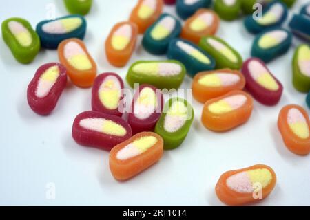 Interessanti e insolite caramelle colorate, dolci con centro bianco sono collocati su uno sfondo bianco opaco. Foto Stock