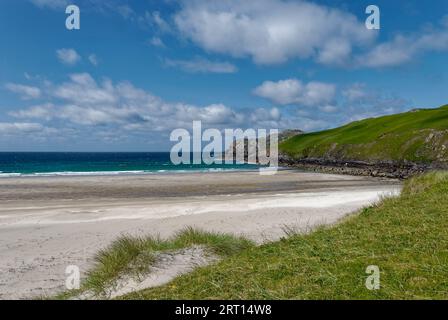 L'estremità settentrionale della spiaggia di Valtos con la sua sabbia bianca sotto le scogliere ricoperte di erba in una giornata luminosa di giugno sull'isola di Lewis. Foto Stock