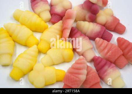 Bellissime e luminose foto di dolci e caramelle. Caramelle colorate in gelatina sotto forma di torte, gelati, squisiti dolcetti disposti su sfondo bianco. Foto Stock