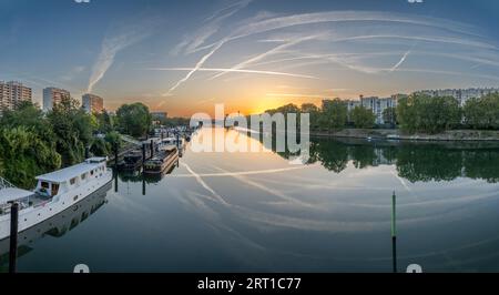 Gennevilliers, Francia - 05 06 2023: Vista panoramica del fiume Senna e del quartiere di Saint-Denis dal ponte Clichy all'alba Foto Stock