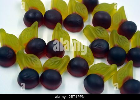 Bellissime e luminose foto di dolci e caramelle. Caramelle colorate in gelatina sotto forma di ciliegie, ciliegie con foglie verdi, dolci. Foto Stock