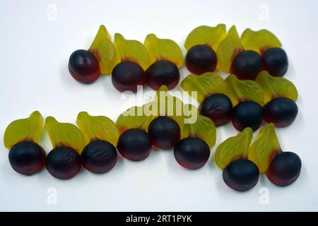 Bellissime e luminose foto di dolci e caramelle. Caramelle colorate in gelatina sotto forma di ciliegie, ciliegie con foglie verdi, dolci. Foto Stock