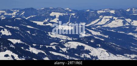 Colline innevate, boschi e terreni agricoli Foto Stock