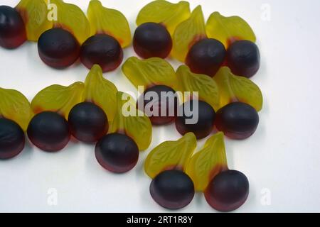 Bellissime e luminose foto di dolci e caramelle. Caramelle colorate in gelatina sotto forma di ciliegie, ciliegie con foglie verdi, dolci. Foto Stock