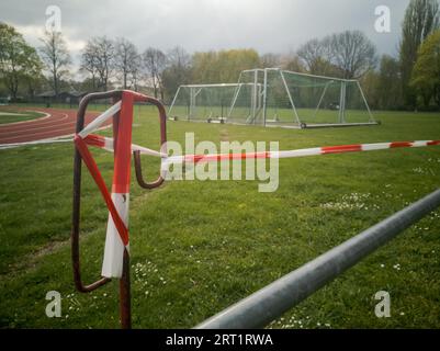 Campo di calcio all'aperto bloccato con nastro barriera durante il blocco pandemico Corona il Lunedi di Pasqua 2020 a Regensburg, Baviera, Germania Foto Stock