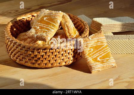 Biscotti allo zucchero dolce con un primo piano in un cestino di vimini su sfondo di legno Foto Stock