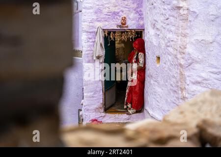 Jaisalemer, India, 5 dicembre 2019: Una donna indiana in abiti colorati in piedi di fronte alla sua casa Foto Stock