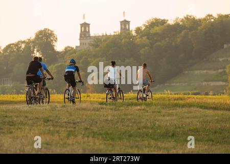 Ciclisti sulla pista ciclabile dell'Elba alla luce della sera di fronte al castello di Albrechtsberg Foto Stock