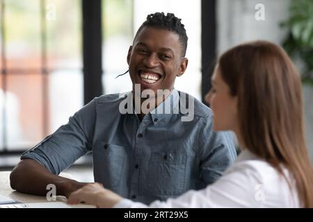 Sorridenti colleghi multirazziali si divertono a collaborare alla riunione Foto Stock