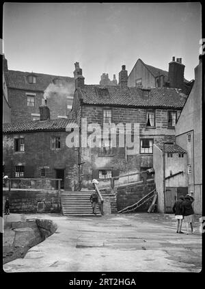 Tate Hill, Whitby, Scarborough, North Yorkshire, 1925-1935. Una vista lungo il Molo di Tate Hill verso le case di Tate Hill a Whitby. Foto Stock