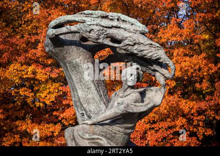 Monumento Chopin contro gli alberi autunnali nel Parco Lazienki di Varsavia, Polonia, statua in bronzo del compositore e pianista polacco Frederic Chopin Foto Stock