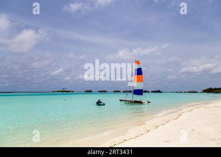 Paradise Island, Maldive, 28 agosto 2018: Un catamarano a vela con una vela colorata Foto Stock