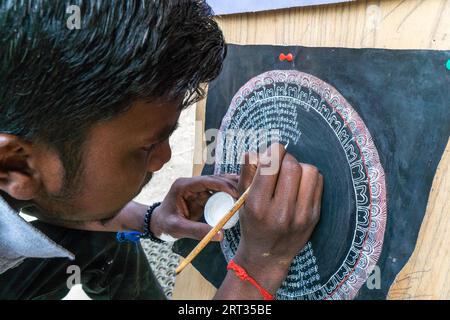 Leh, India, 24 agosto 2018: Uomo che disegna un simbolo buddista per le strade di Leh. Editoriale illustrativo Foto Stock