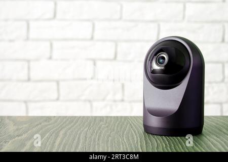 Moderna telecamera IP IP HD di sicurezza sul tavolo all'interno della camera. Concetto di controllo e monitoraggio e sicurezza in casa Foto Stock