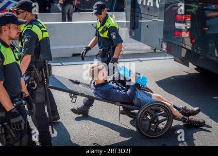 L'Aia, Olanda meridionale, Paesi Bassi. 9 settembre 2023. La polizia olandese usa barelle riadattate per spostare gli attivisti del clima arrestati. Il 9 settembre 2023, gli attivisti della ribellione di estinzione bloccarono l'autostrada A12 che attraversava il centro dell'Aia, nei Paesi Bassi. La protesta era in opposizione ai miliardi di euro del governo olandese in sovvenzioni all'industria dei combustibili fossili. (Immagine di credito: © James Petermeier/ZUMA Press Wire) SOLO USO EDITORIALE! Non per USO commerciale! Foto Stock