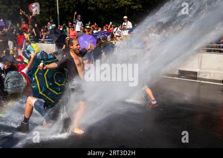 L'Aia, Olanda meridionale, Paesi Bassi. 9 settembre 2023. La polizia olandese spruzza gli attivisti del clima con cannoni ad acqua. Il 9 settembre 2023, gli attivisti della ribellione di estinzione bloccarono l'autostrada A12 che attraversava il centro dell'Aia, nei Paesi Bassi. La protesta era in opposizione ai miliardi di euro del governo olandese in sovvenzioni all'industria dei combustibili fossili. (Immagine di credito: © James Petermeier/ZUMA Press Wire) SOLO USO EDITORIALE! Non per USO commerciale! Foto Stock