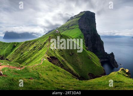 Kallur faro sulle verdi colline di Kalsoy isola, isole Faerøer, Danimarca. Fotografia di paesaggi Foto Stock