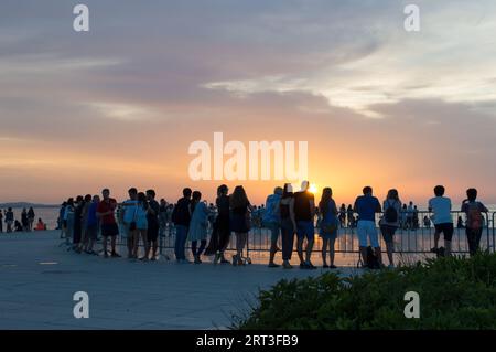 Zara, Croazia - 15 giugno 2019: I turisti che ammirano un incredibile tramonto sulla famosa installazione di saluti al sole a Zara Foto Stock