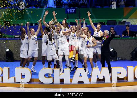 Pasay, Indonesia. 10 settembre 2023. Pallacanestro, Coppa del mondo, Serbia - Germania, round a eliminazione diretta, finale, il tedesco Dennis Schröder (4° da sinistra) solleva il trofeo durante la cerimonia di premiazione e celebra il titolo della Coppa del mondo con la squadra. Sulla destra, l'allenatore nazionale Gordon Herbert. Crediti: Matthias Stickel/dpa/Alamy Live News Foto Stock